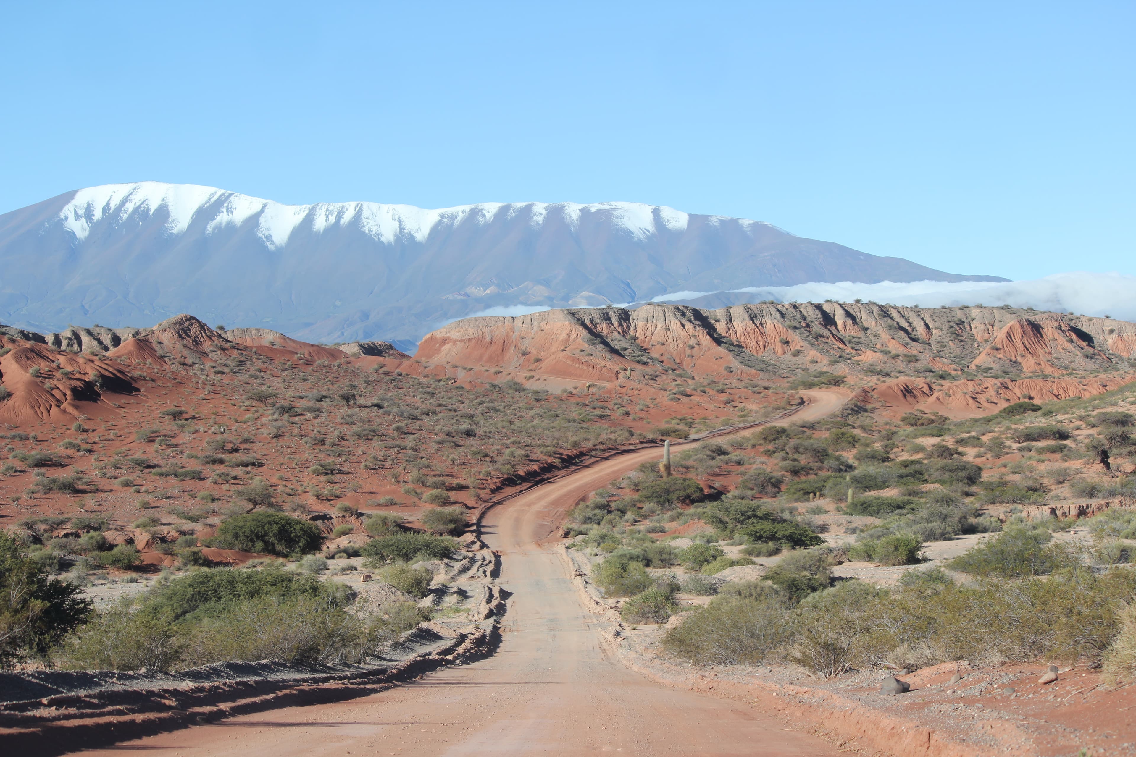 Quebrada de las Flechas, Argentina, with a dirt road toward snow-capped mountains